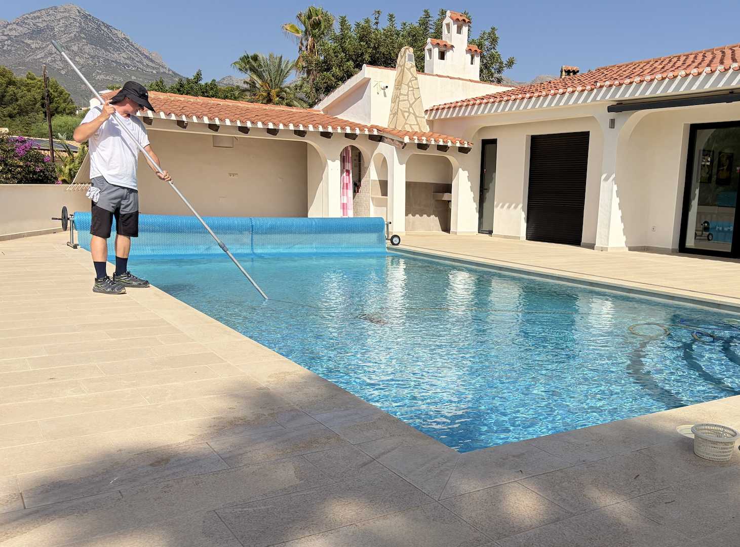 Pool technician vacuuming the floor of a private swimming pool during pool cleaning